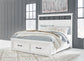 Cama Ashbryn King con cabecero, tocador con espejo, cómoda y mesita de noche.