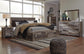 Cama Derekson tamaño King con cabecero y cuatro cajones, tocador con espejo, cómoda y mesita de noche.